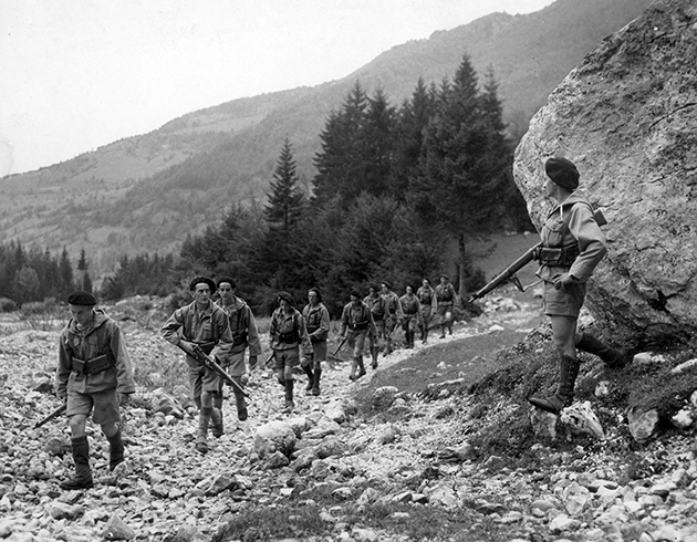 Soldats français ayant pris le maquis en signe de résistance, avançant sur un sentier de montagne, 1944. © Alinari / Roger-Viollet