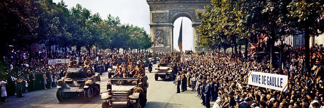 Foule sur les Champs Élysées regardant les blindés de la 2e DB avec des banderoles 