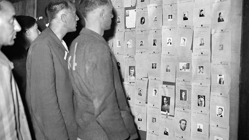 Des déportés rapatriés à l'hôtel Lutétia consultent les listes des survivants des camps. Paris (France), mai 1945.  Mémorial de la Shoah/coll. AFP