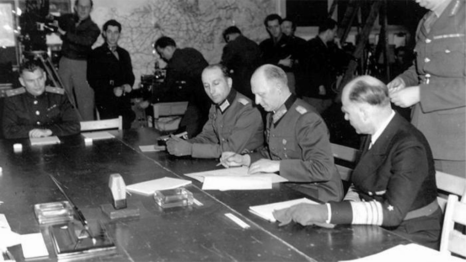 Le général Jodl signant l'acte de reddition des forces armées allemandes du IIIe Reich, le 7 mai 1945, à Reims. © Musée de la Reddition