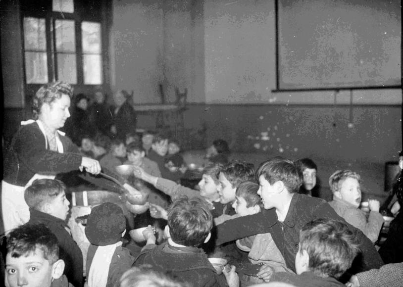 Dans une salle de classe, des repas sont distribués à des enfants réfugiés, 1er septembre-31 décembre 1944